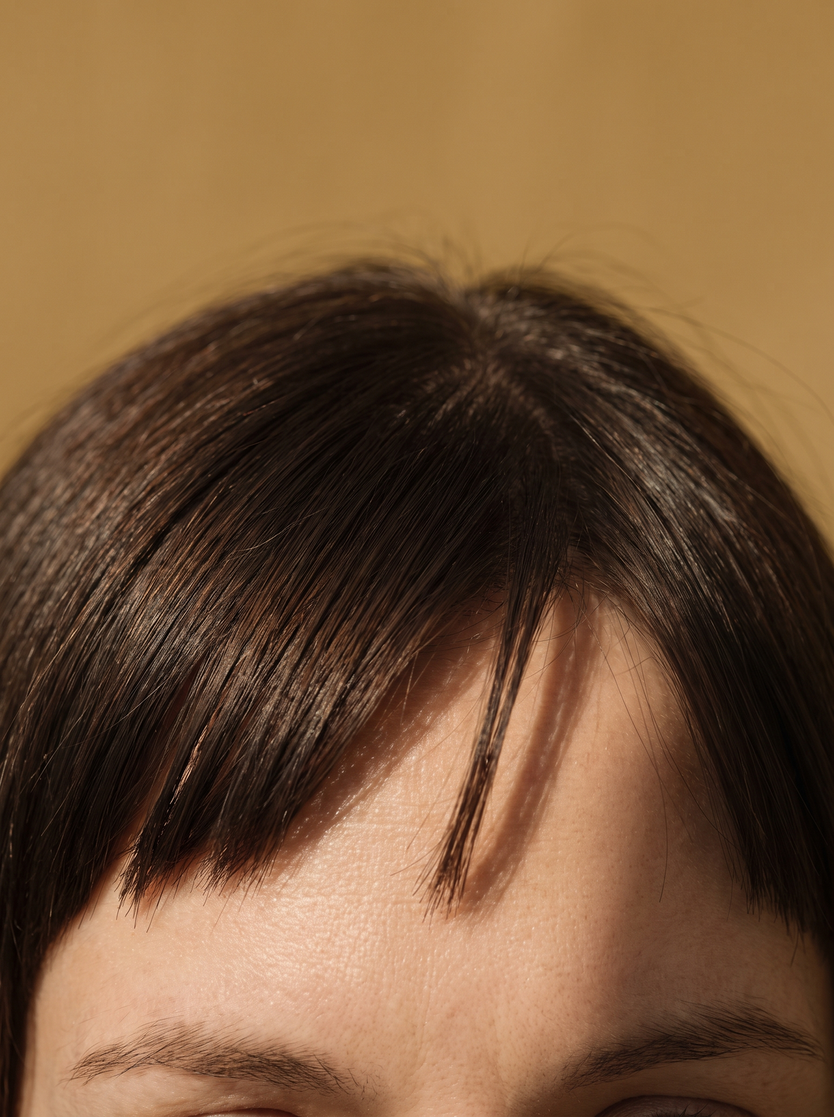 forehead with straight bangs resting on the skin