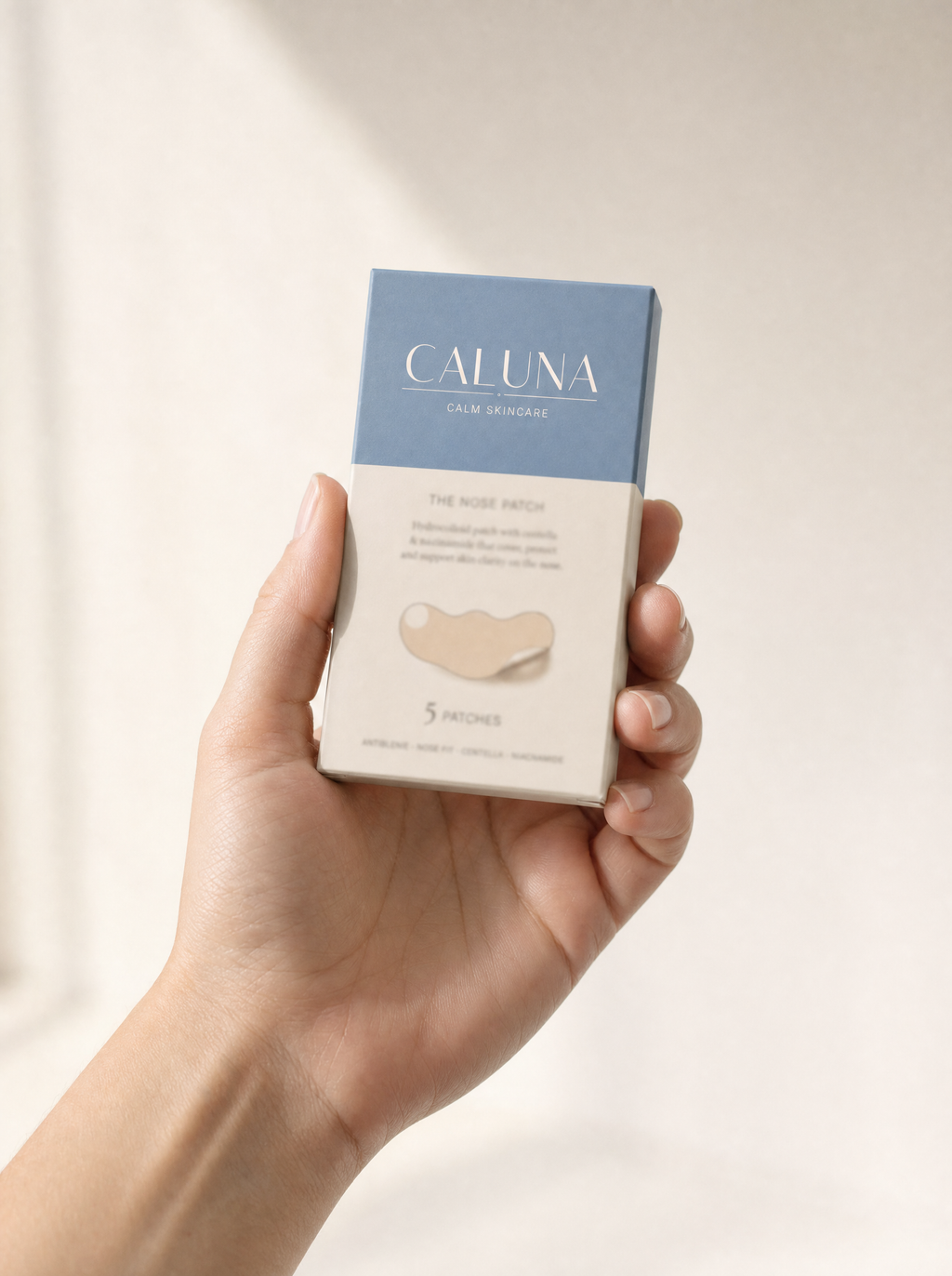The Nose Patch box held in a hand, showing its palm-sized scale