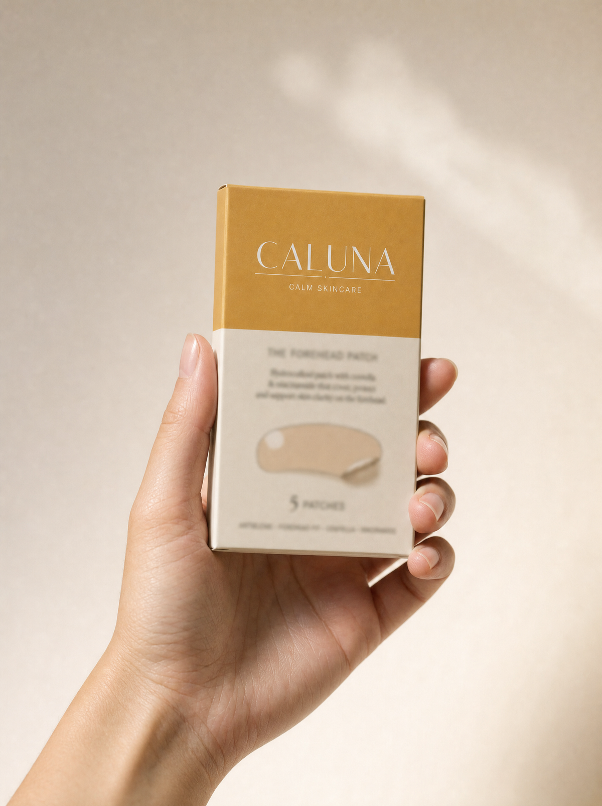 The Forehead Patch box held in a hand, showing its palm-sized scale